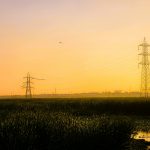 a field with power lines in the distance