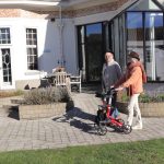 Two people with a walker on a patio