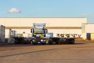 Truck and trailers parked in front of a warehouse.